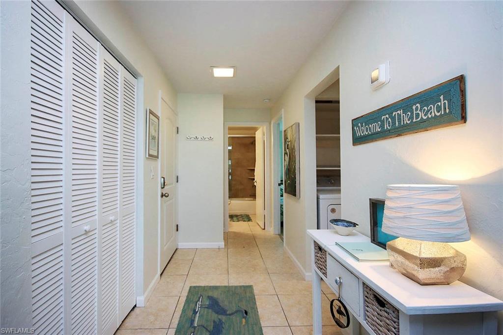 Image 2: Hallway featuring light tile patterned flooring and washer / dryer