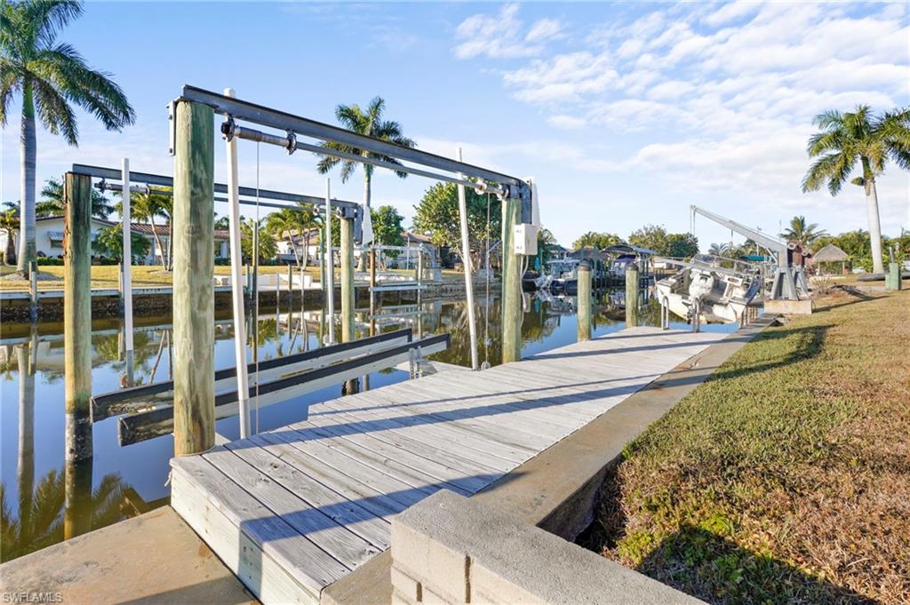 Image 4: Dock area featuring boat lift, boat dock and concrete seawall provides you direct boating access to the Caloosahatchee River and Gulf.