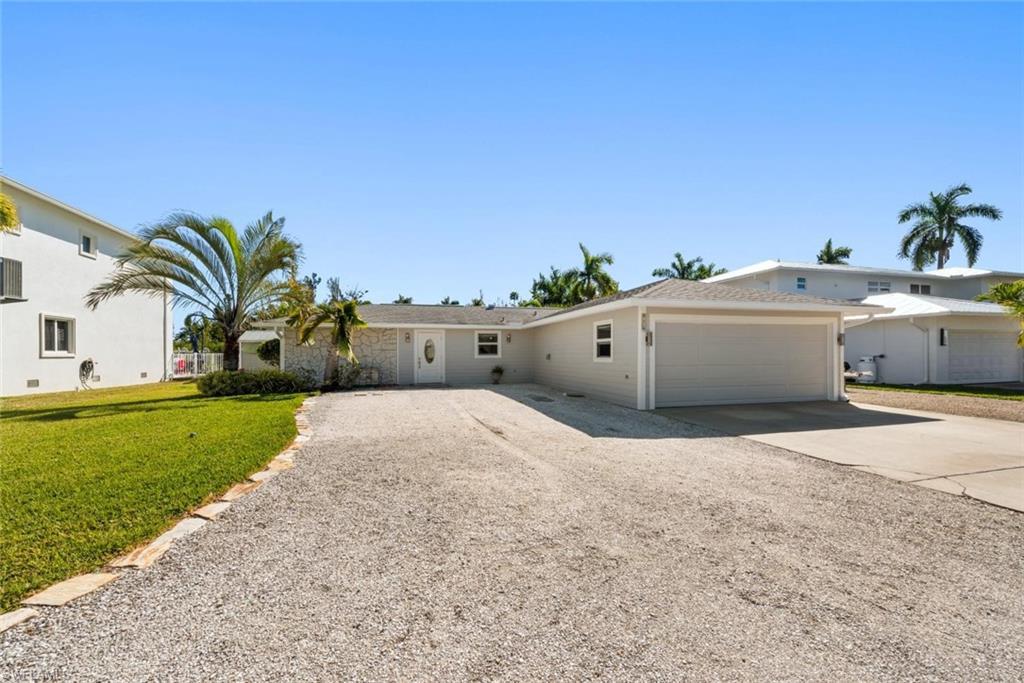Image 3: View of front facade featuring driveway, an attached garage, and a front lawn