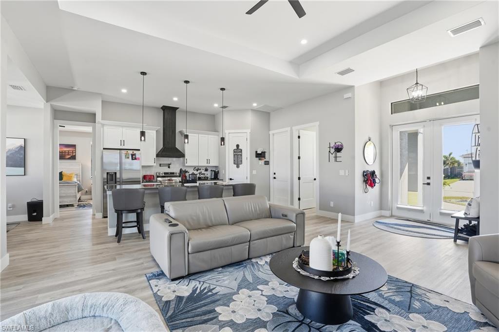 Image 3: Living area featuring light wood-style flooring, french doors, ceiling fan, and recessed lighting