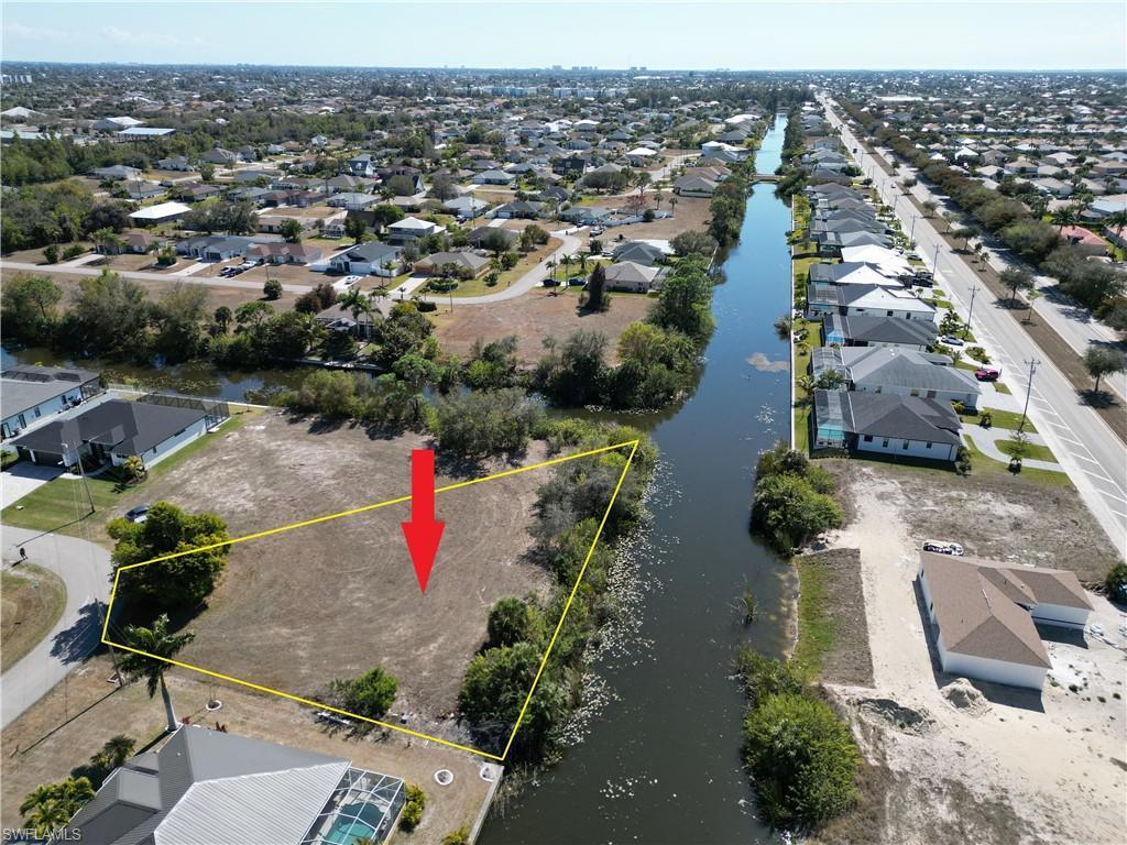 Image 1: Aerial view of residential area with property parcel outlined and view of freshwater canal