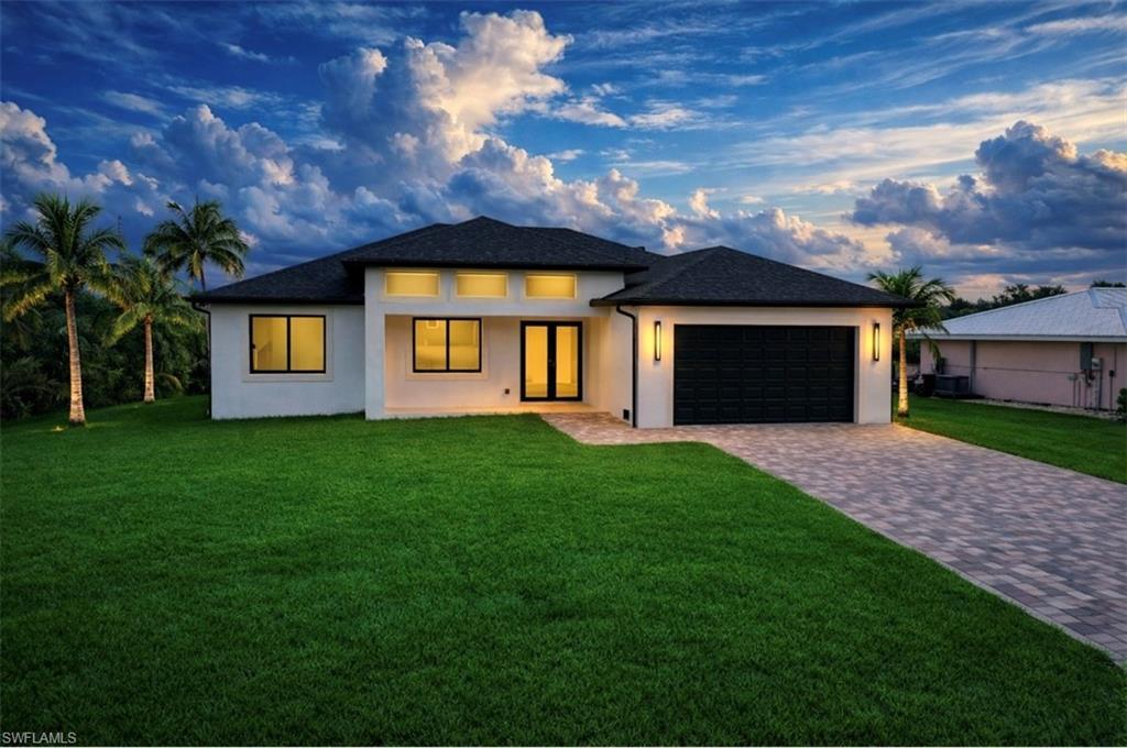 Image 2: Prairie-style house featuring a yard, stucco siding, decorative driveway, and an attached garage (Rendered photo)