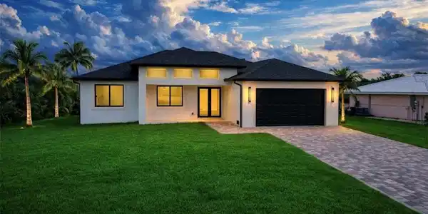 Image 2: Prairie-style house featuring a yard, stucco siding, decorative driveway, and an attached garage (Rendered photo)
