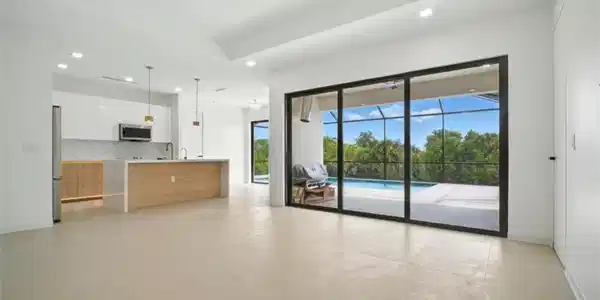 Image 3: Unfurnished living room featuring a ceiling fan, a sunroom, a tray ceiling, concrete floors, and recessed lighting