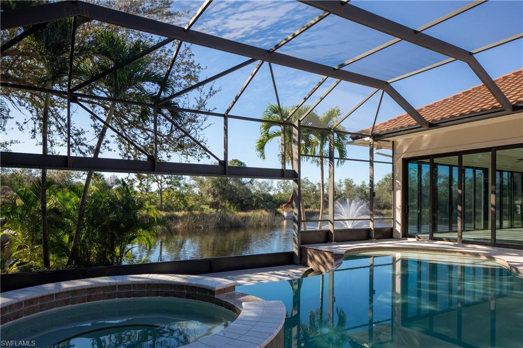 Image 2: View of swimming pool with a sunroom, a pool with connected hot tub, a lanai, a patio area, and a water view
