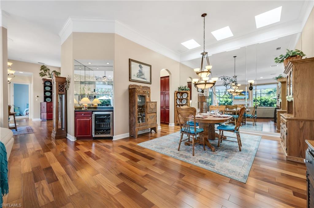 Image 3: Main dining room with wall of mirrors to highlight the reflection of the outdoors!  Bar with wine cooler is located between the two family and living rooms for perfect entertaining ease.