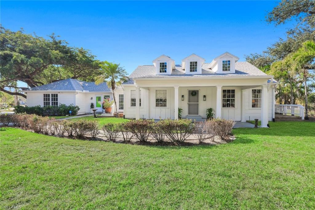 Image 2: View of front facade featuring a front yard and covered porch