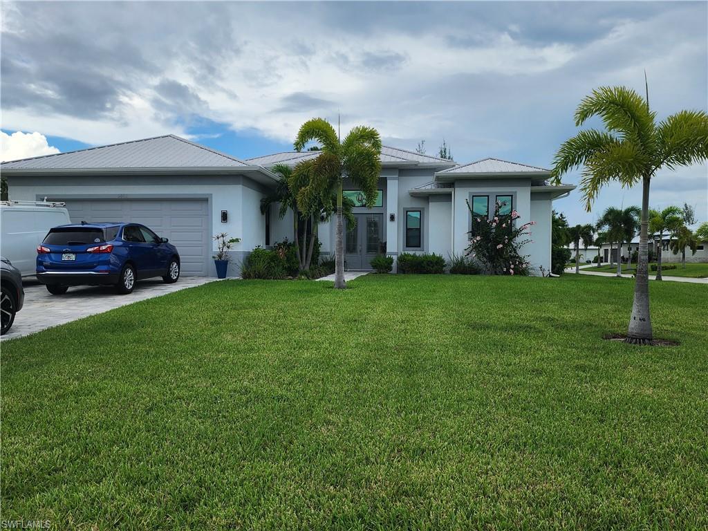 Image 2: Ranch-style house featuring a front yard, stucco siding, an attached garage, french doors, and pavered driveway