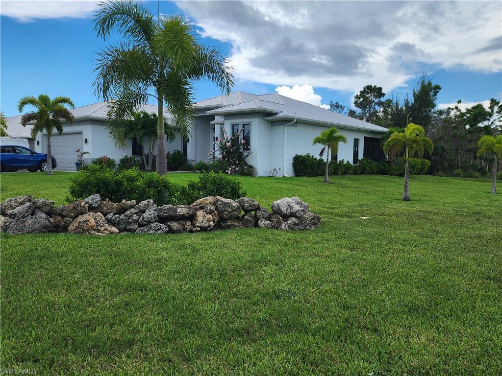 Image 3: View of front of house featuring a two car garage, an oversized corner lot, and stucco siding