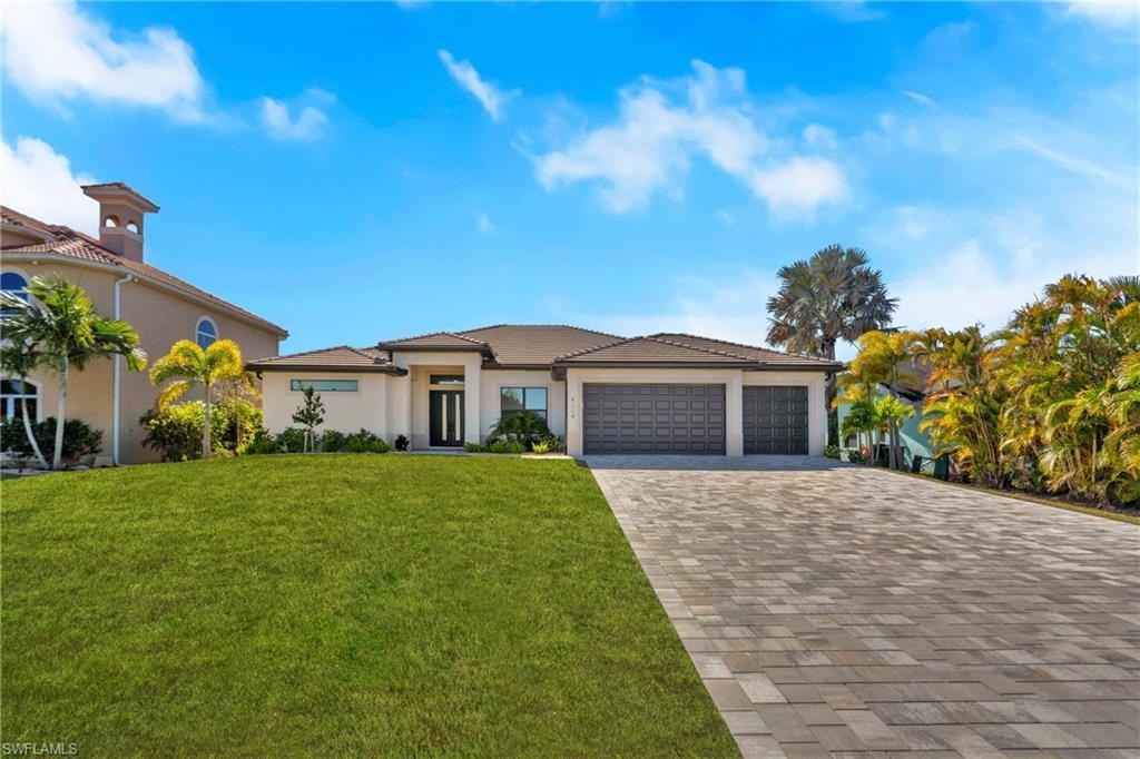 Image 3: Prairie-style house featuring a front yard, stucco siding, decorative driveway, and an attached garage