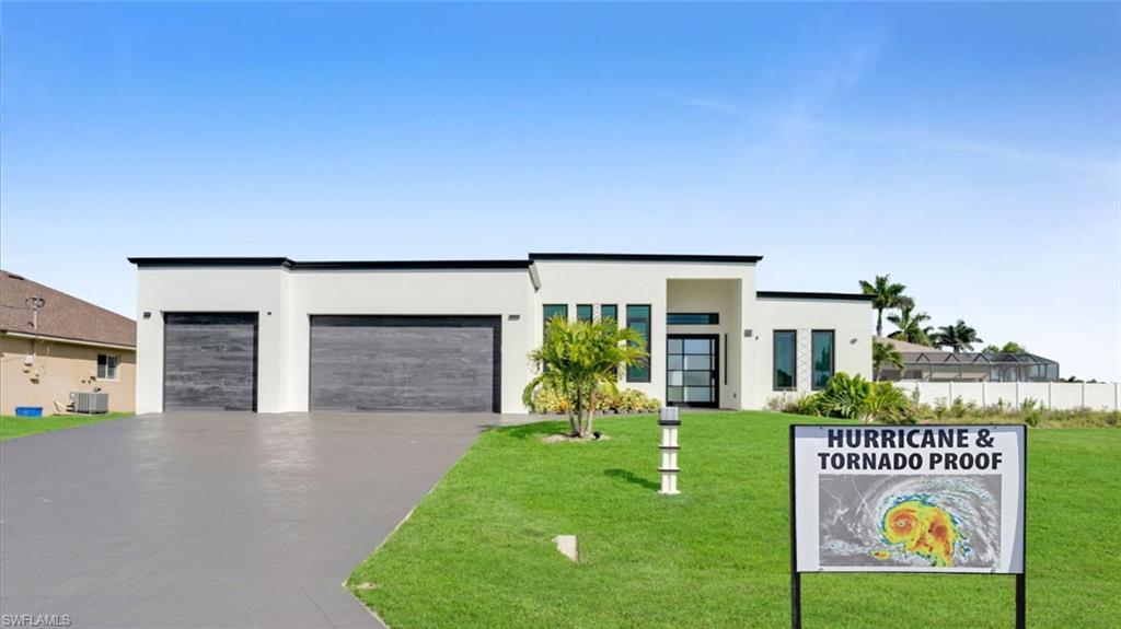 Image 1: Contemporary home featuring a garage, driveway, and stucco siding