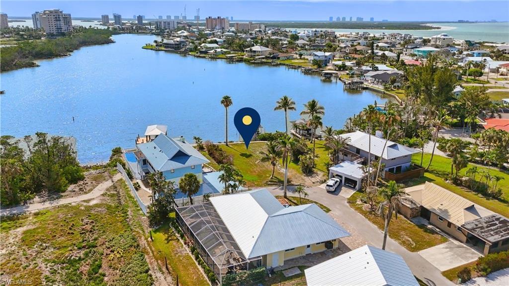 Image 2: Aerial view of residential area with a nearby body of water and skyline  VIRTUALLY ENHANCED