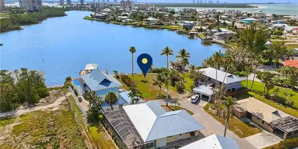 Image 2: Aerial view of residential area with a nearby body of water and skyline  VIRTUALLY ENHANCED