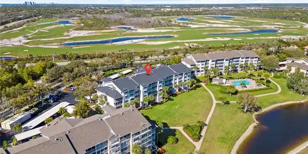 Image 2: Aerial view of property's location featuring a nearby body of water and a golf course
