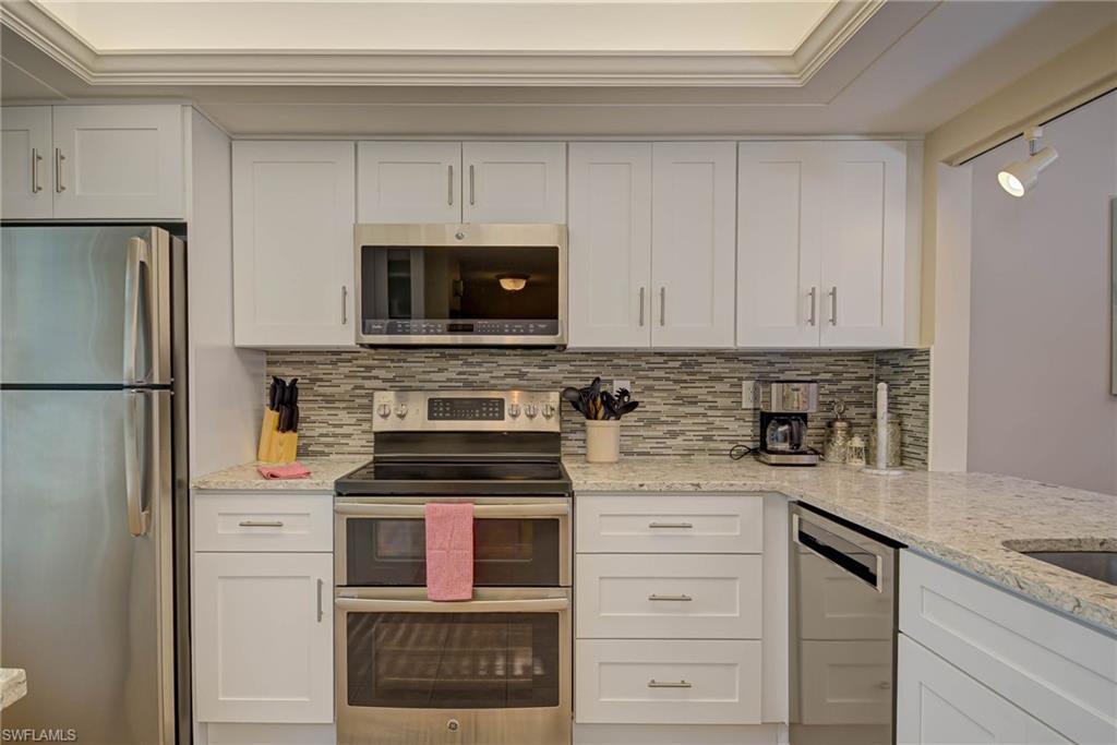 Image 3: Kitchen featuring stainless steel appliances and white cabinets