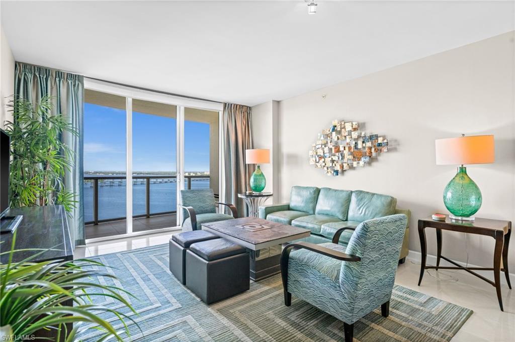 Image 1: Living room with floor to ceiling windows and a water view