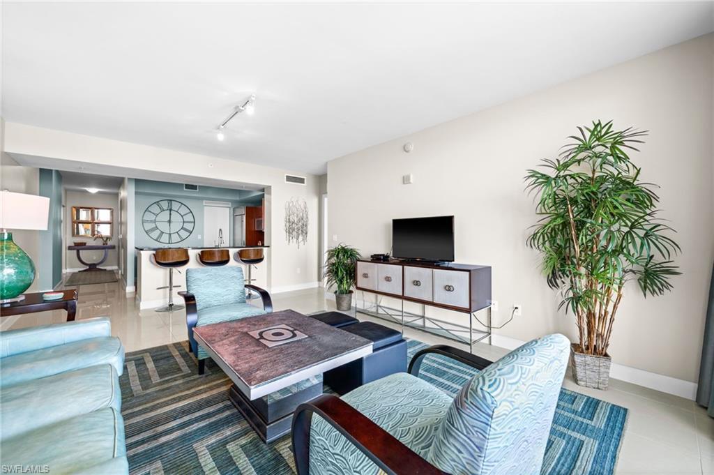 Image 2: Living area featuring tile patterned floors and rail lighting