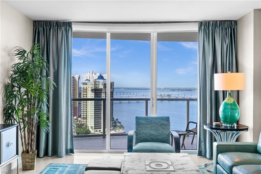 Image 4: Living area with a water view, expansive windows, and tile patterned floors