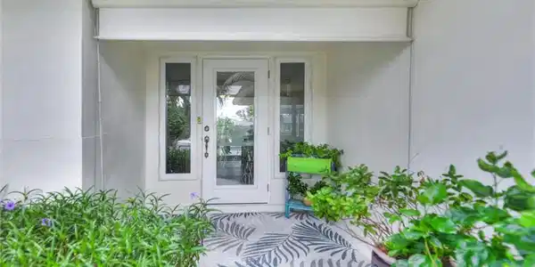 Image 3: Property entrance featuring stucco siding
