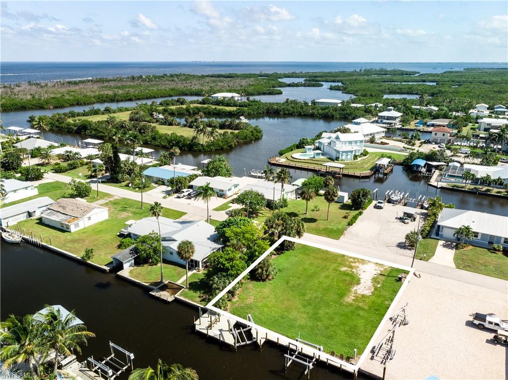 Image 1: Aerial perspective of suburban area with a nearby body of water and property boundaries highlighted