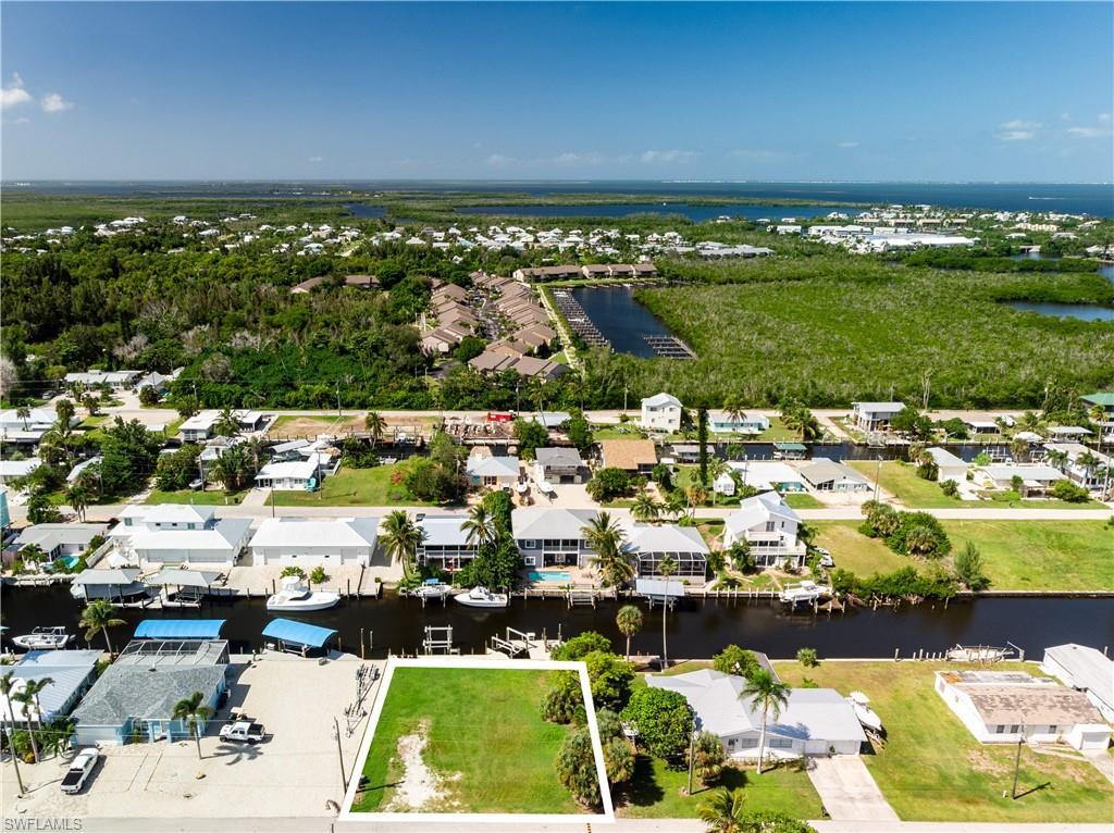 Image 2: Aerial view of residential area featuring a nearby body of water