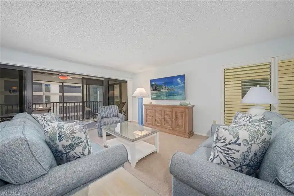 Image 1: Living area with a textured ceiling, carpet, and ceiling fan