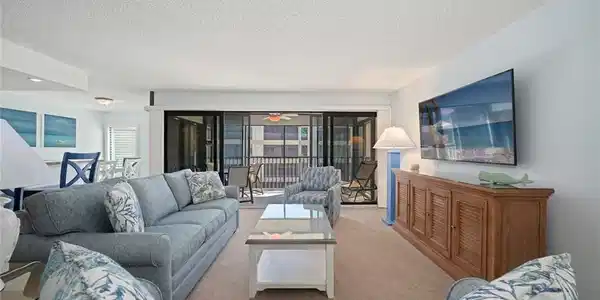 Image 3: Carpeted living area with a textured ceiling