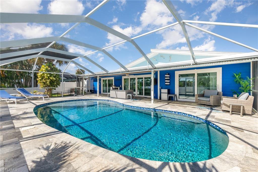 Image 4: Enjoy SWFL lifestyle w/large screened-in lanai, covered sitting area and saltwater pool with travertine tile pavers.