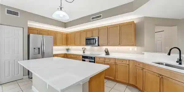 Image 2: The sellers have recently elevated the kitchen with newly installed quartz countertops and a beautifully redesigned island&mdash;perfect for gathering with guests while the chef prepares meals. Enhanced with under- and over-cabinet lighting, brand-new stainless steel appliances, and a fresh, refined repaint throughout, the space exudes a bright, modern sophistication, creating a truly inviting and refreshed culinary environment.