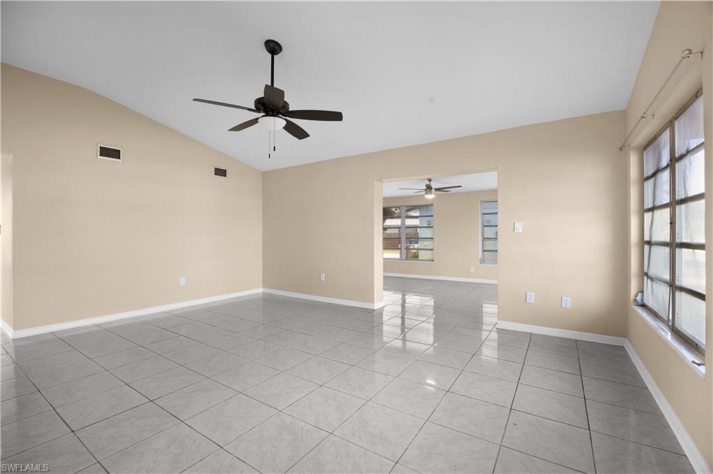 Image 2: Empty room featuring light tile patterned floors, vaulted ceiling, and ceiling fan