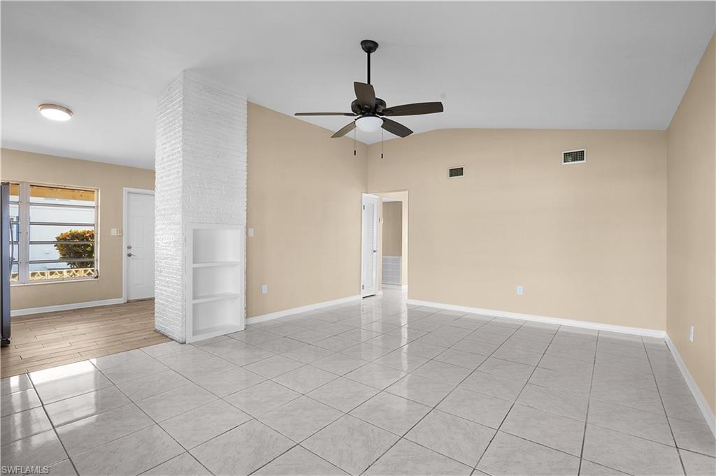 Image 3: Empty room featuring light tile patterned flooring, vaulted ceiling, and a ceiling fan