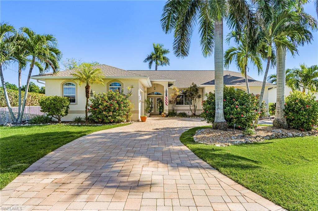 Image 2: Ranch-style home featuring a front yard, decorative driveway, stucco siding, and french doors