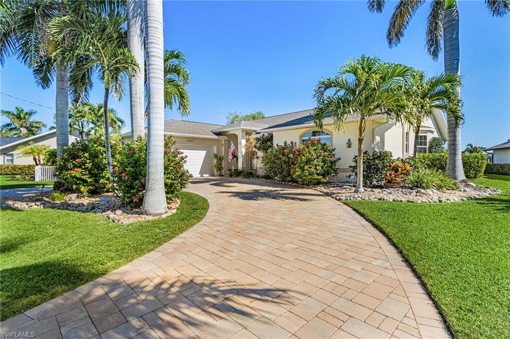 Image 3: Ranch-style home with a front yard, stucco siding, an attached garage, and decorative driveway