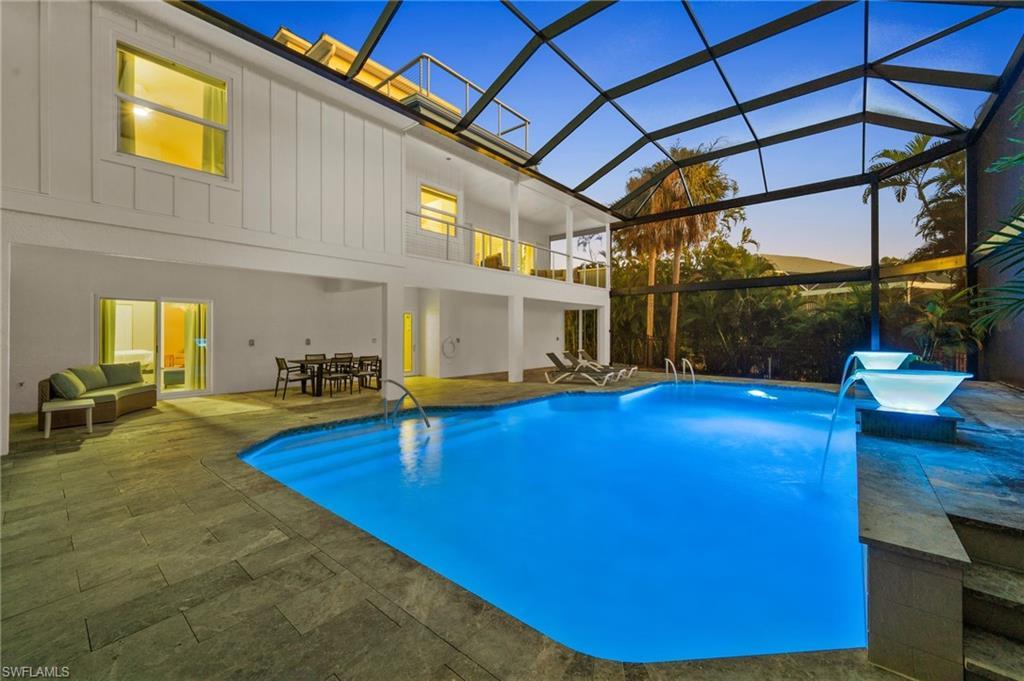 Image 2: Pool at dusk featuring an outdoor pool, a two story re-inforced no-see um screened pool enclosure!!