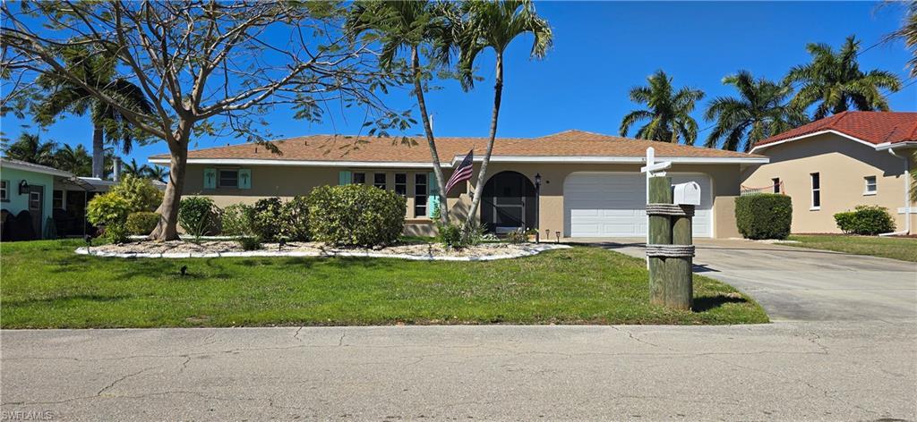 Image 2: Single story home with a garage, driveway, a front yard, and stucco siding