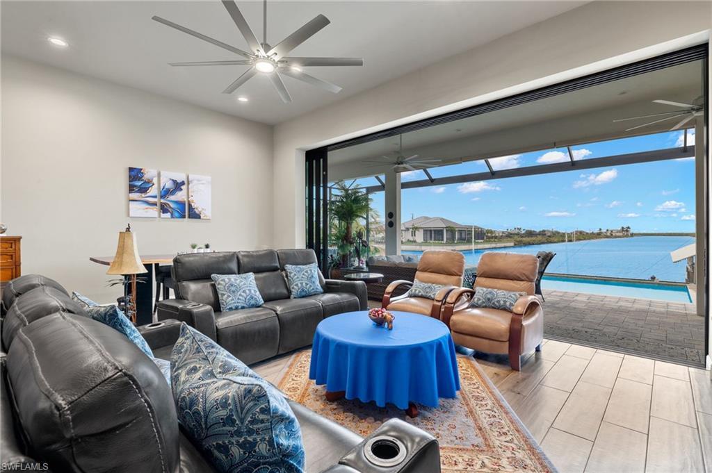 Image 2: Living room featuring amazing water views, wood tiled floors, a sunroom, and recessed lighting