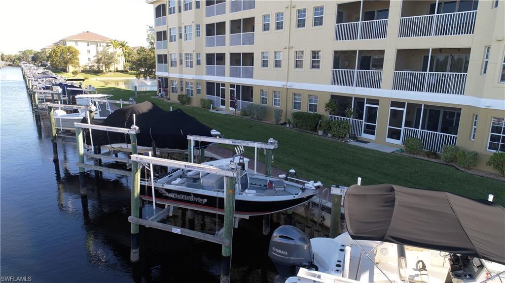 Image 1: Dock featuring boat lift and a water view