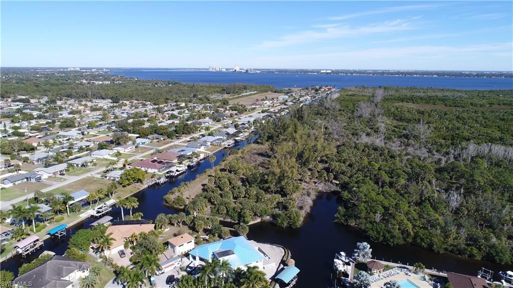 Image 4: Aerial overview of property's location featuring a nearby body of water and nearby suburban area