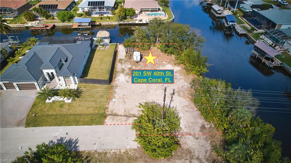 Image 2: Aerial perspective of suburban area with property parcel outlined and a large body of water