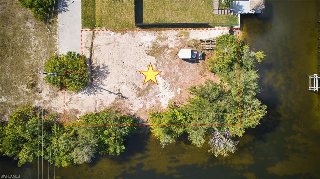 Image 4: Aerial view of property and surrounding area with a nearby body of water and property boundaries highlighted