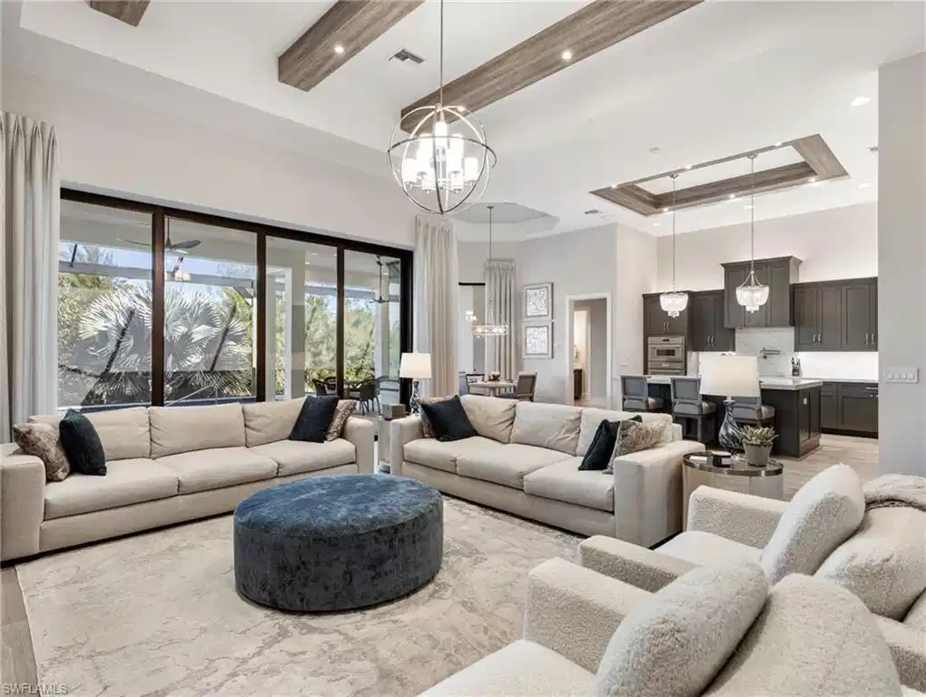 Image 1: Living area with a tray ceiling, a high ceiling, recessed lighting, and a chandelier