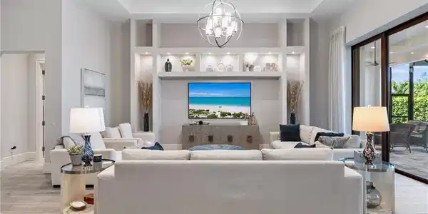Image 2: Living room featuring a raised ceiling, light wood-style floors, a high ceiling, a chandelier, and recessed lighting