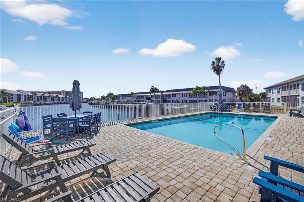 Image 4: Community pool featuring a patio area and outdoor dining area