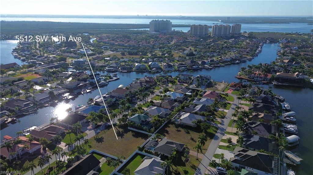 Image 3: Aerial view of property and surrounding area featuring a large body of water and nearby suburban area