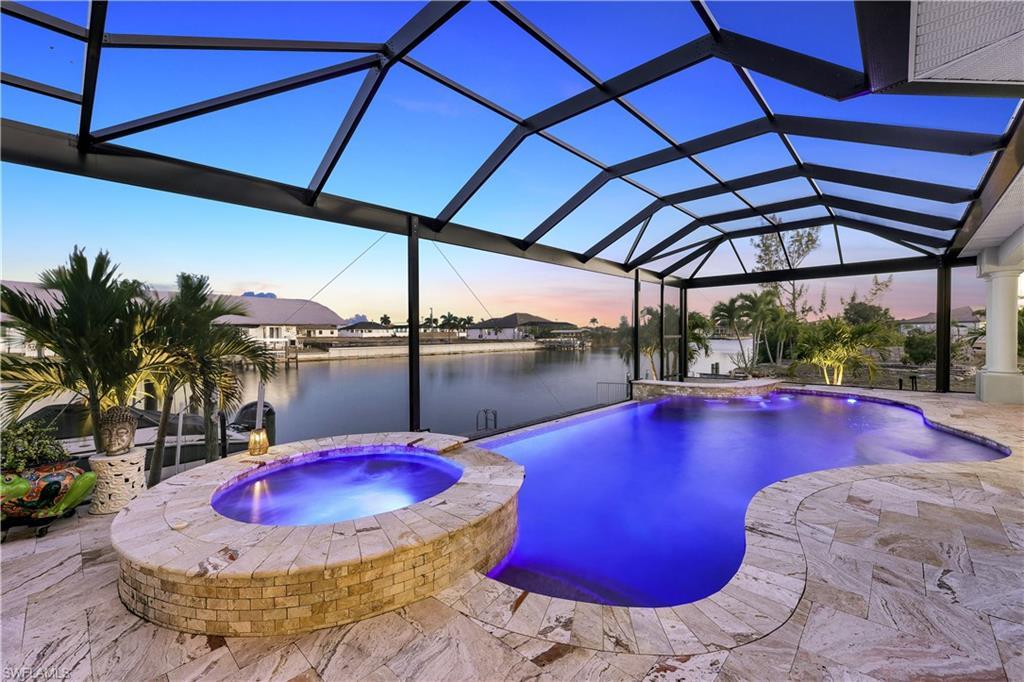 Image 2: Integrated pool / spa featuring a sunroom, glass enclosure, a patio, and a water view
