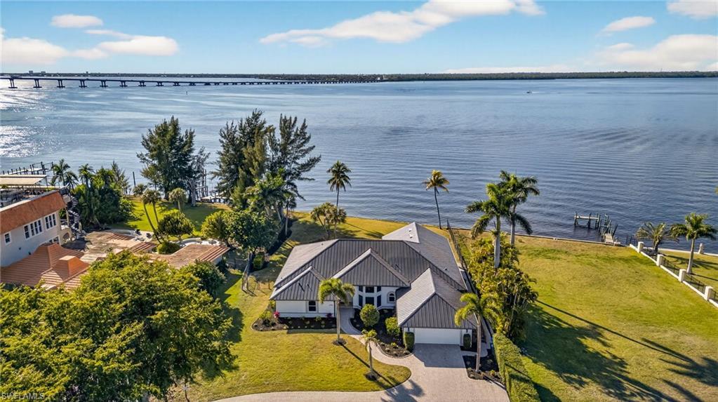 Image 1: Aerial view of property and surrounding area featuring a nearby body of water