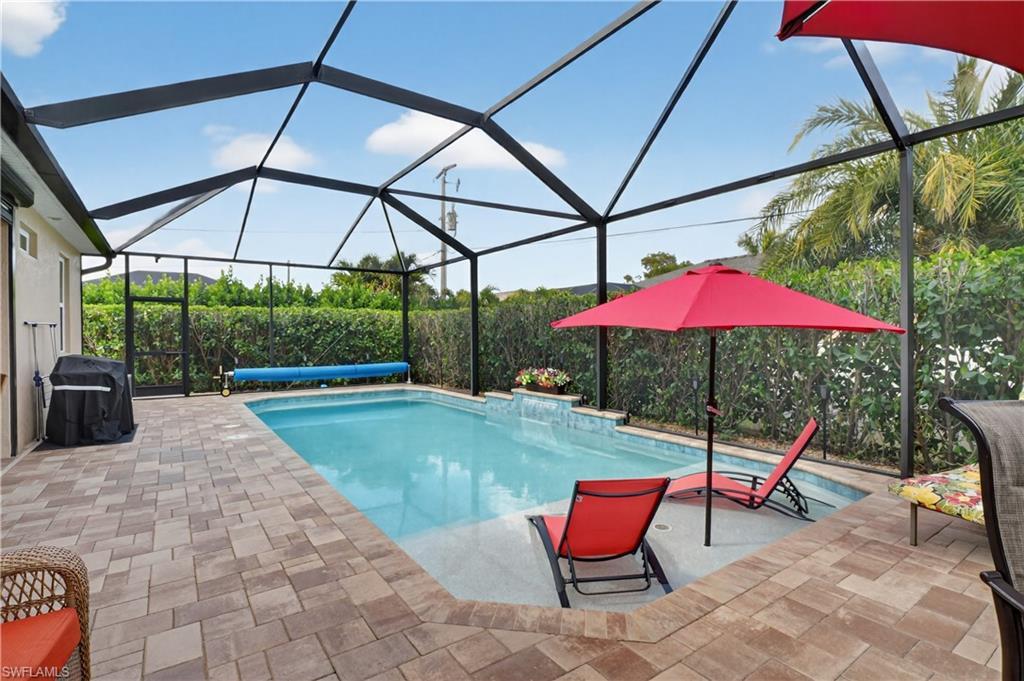 Image 1: Swimming pool with a sunroom, glass enclosure, and area for grilling