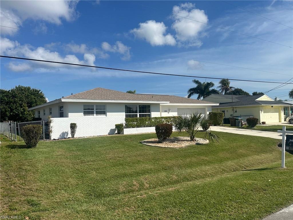 Image 2: Ranch-style home with a garage, a front yard, concrete driveway, and brick siding