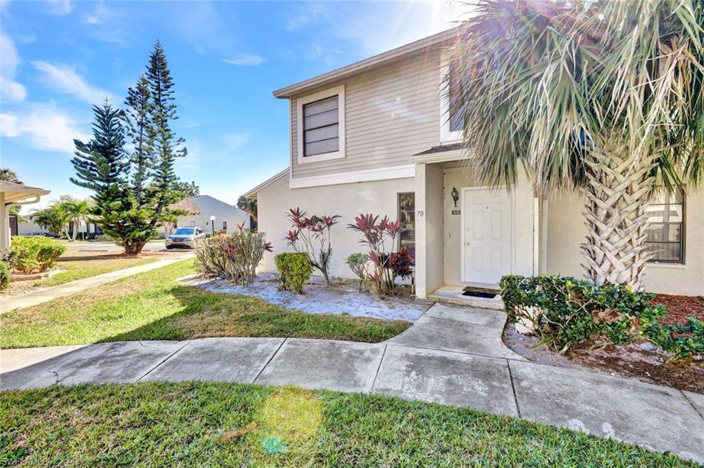 Image 2: View of front of house with stucco siding and a front lawn