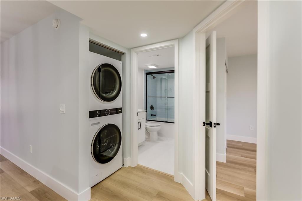 Image 4: Laundry area with stacked washer / dryer, light wood-style floors, and recessed lighting